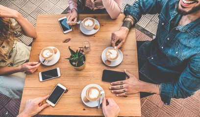 Happy friends drinking cappuccino inside vintage bar - Top view of trendy young people doing...