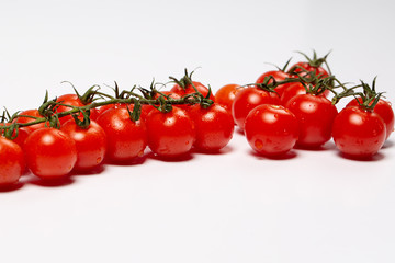 Cherry tomatoes covered drops on a white background