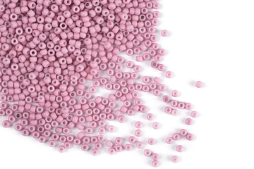 Pink scattered beads on a white background, top view, costume jewelry