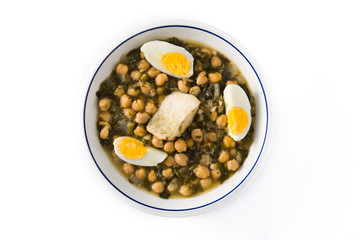 Chickpea stew with spinach and cod or potaje de vigilia isolated on white background. Top view