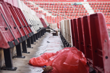 Red and white stadium seats after a rainy match