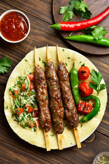 Turkish Adana Kebab with fresh vegetables on flatbread