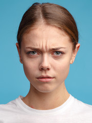 emotional portrait of a young attractive girl. Studio shooting, blue background