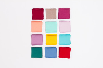 Pieces of colored fabric lined with a square on a white background