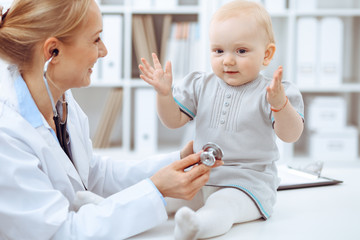 Doctor and patient in hospital. Little girl is being examined by doctor with stethoscope. Medicine concept