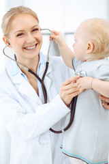 Doctor and patient in hospital. Little girl is being examined by doctor with stethoscope. Medicine concept