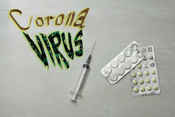 pills with syringe and text coronavirus