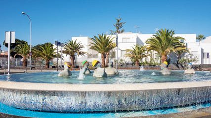 Fountain with tourists in a swimming pool, situated on the corner of the main road Avenida Jose Antonio Tavio and Calle Diana,  Costa del Silencio, Tenerife, Canary Islands, Spain