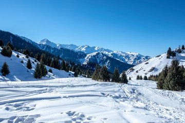 Fototapeta na wymiar Trail in mountains in winter sunny day.