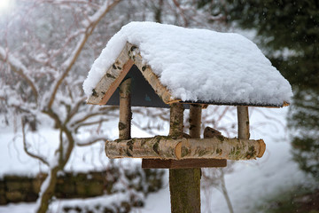 Bird feeder in winter covered with snow. Home made. Helping birds in winter