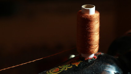 spool of brown thread on a sewing machine