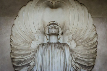 La statua di un angelo dalle grandi ali su una  tomba del cimitero monumentale di Bologna