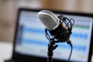 technology and audio equipment concept - close up of microphone at recording studio or radio station