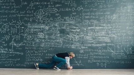 Time lapse of smart student handsome young man writing formulas on blackboard working at scientific exercise alone. Education and people concept.