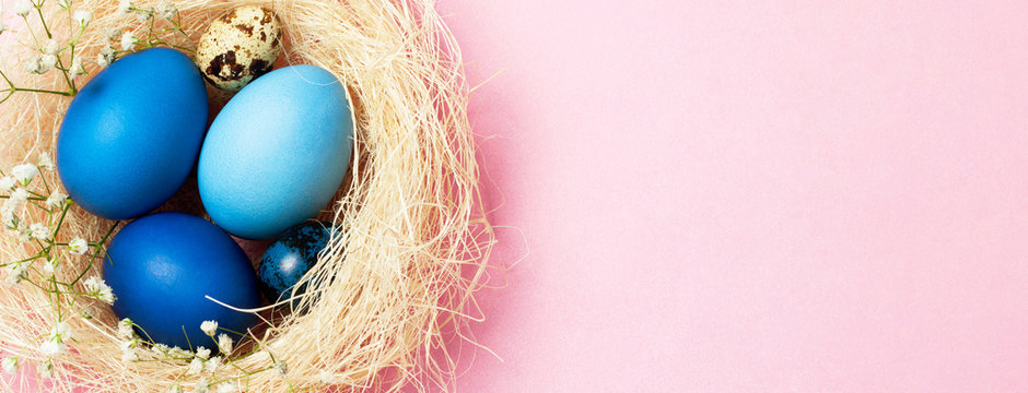 Banner with Easter eggs in blue colors in a nest. Copy space. The concept of stylish decoration for Easter, greeting cards, etc.