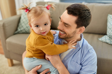 family, parenthood and fatherhood concept - father with little baby daughter at home
