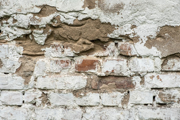 Old damaged brick wall with plaster background texture.