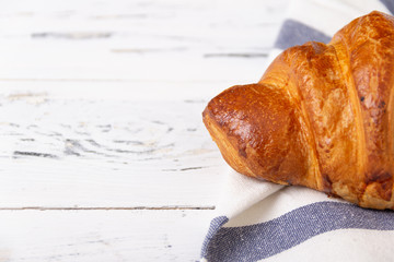 French rosy croissant on light napkin on white background. Bakery concept.
