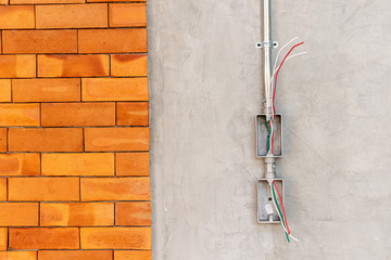 Electrical socket boxes with wires on cement wall in a wall under construction unfinished frame, Unfinished electrical plug box on the cement wall - Interior concept.