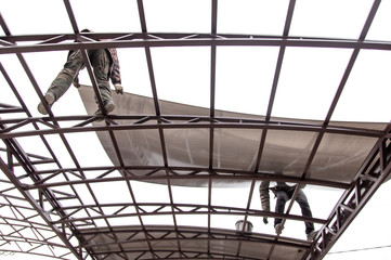 A worker mounts a metal canopy