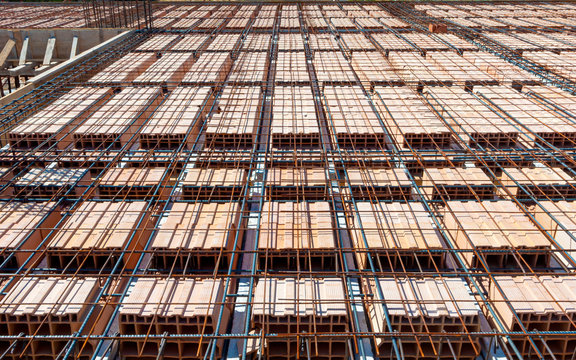 reinforcement of concrete with metal rods connected by wire. view of wooden formwork with metal holders on which the concrete will be laid