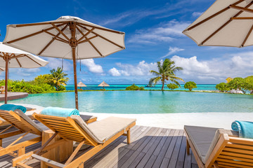 Summer beach vacation pool. Chaise lounge concept, luxury travel. Infinity oceanfront pool with submerged loungers in a luxury resort in Maldives, Indian Ocean