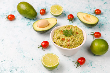 Fototapeta na wymiar Fresh homemade hot guacamole sauce with ingredients on light background,top view