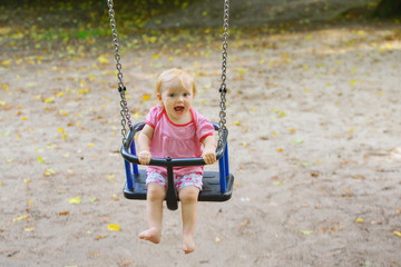 little baby happily rocks on the playground