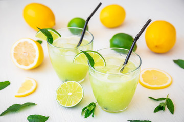 Citrus cold lemonade with lime, mint and lemons in glasses