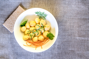 Homemade of curd cottage cheese or lazy dumpling - vareniki with carrots. Useful quick and healthy breakfast. Linen napkin as background. Rustic style