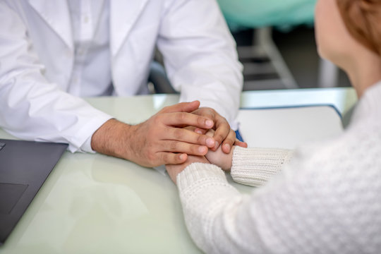 Close up picture of male hands holding his patients hands