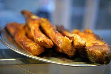 Fried pieces of fish in the showcase of a restaurant.