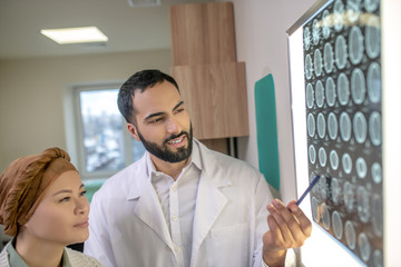 Fototapeta premium Bearded young doctor explaining MRI results to the patient