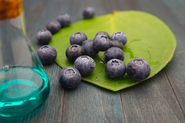 Ripe blueberries spilling onto a green leaf