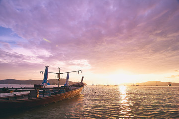 Obraz premium Travel in Thailand. Colorful landscape with sea beach, traditional longtail boat over beautiful sunset background.