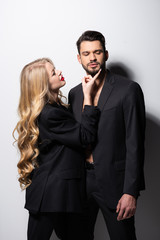 beautiful young woman touching face of bearded man on white