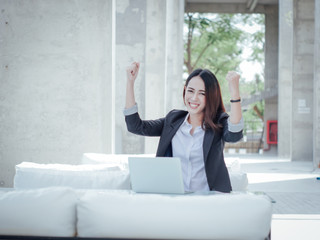 Asian business woman with laptop happy and smile concept success work