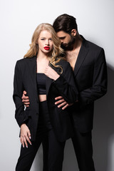 bearded man hugging beautiful girlfriend with red lips on white