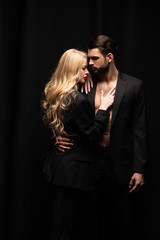attractive woman hugging handsome man isolated on black