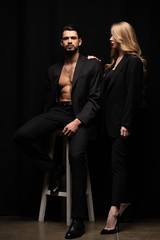 attractive woman standing near bearded man on black