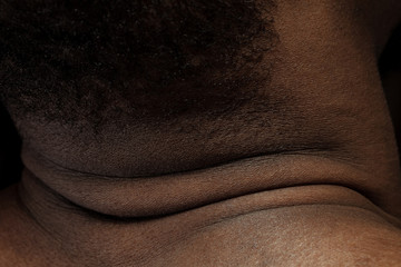 Fototapeta premium Head, neck. Detailed texture of human skin. Close up shot of young african-american male body. Skincare, bodycare, healthcare, hygiene and medicine concept. Looks beauty and well-kept. Dermatology.