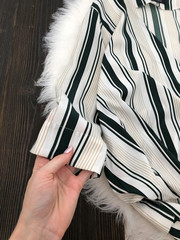 Fabric striped chiffon blouse close-up on a wooden background