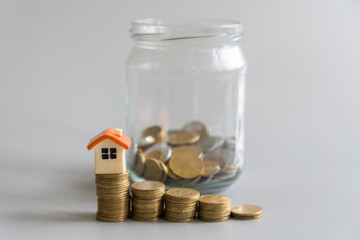 Real estate investment. Saving to buy a house that hand putting money coins, saving money or money growth concept