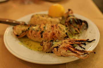 grilled squid on a plate with lemon