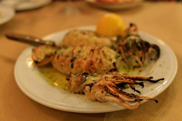 grilled squid on a plate with lemon