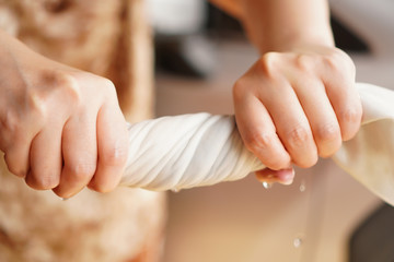 Two hands wring wet cloth after washing by twist and squeeze. Housework ,laundry and optimization concept 