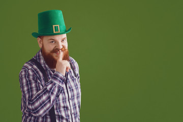 Happy St. Patricks Day. Fat funny man in a green hat smiles on a green background Patricks Day.