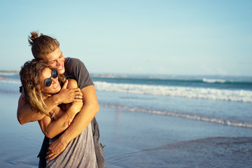 Love and romance. Honeymoon on the sea shore. Happy loving couple embracing on the beach.
