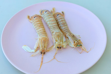 raw shrimp 3 pieces on a pink plate