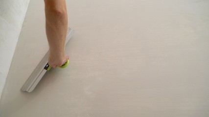 Worker plastering the walls with a spatula. work aligns with a spatula